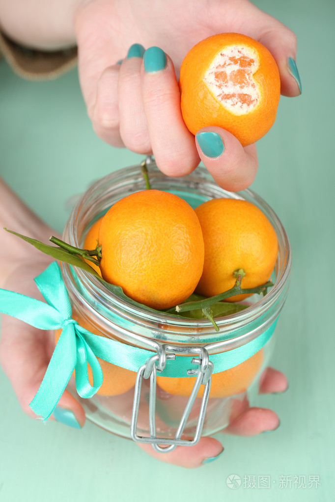 手中拿着成熟的橘子关闭了