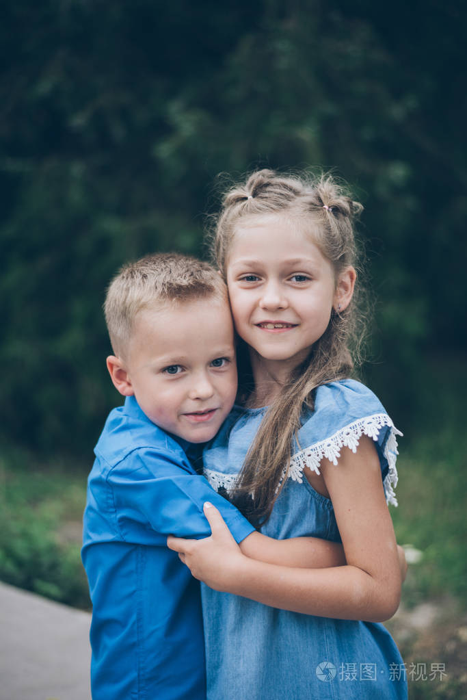 两个快乐有趣的孩子们站在一起拥抱彼此