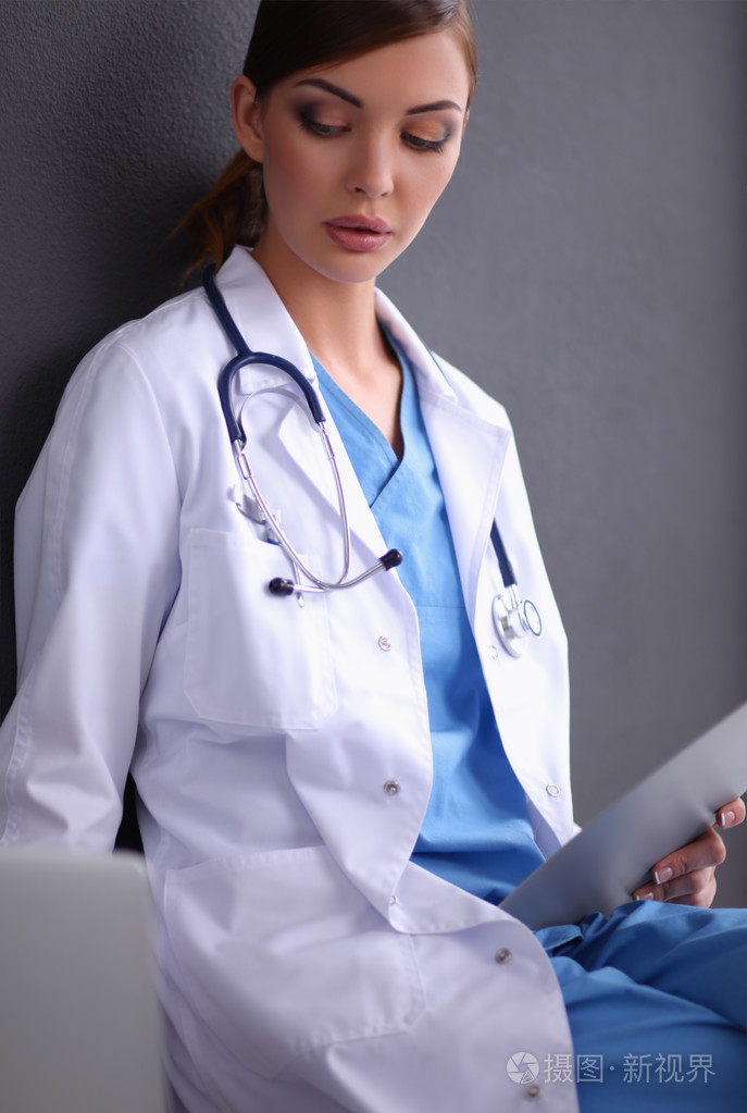 工作上孤立的灰色背景的女医生