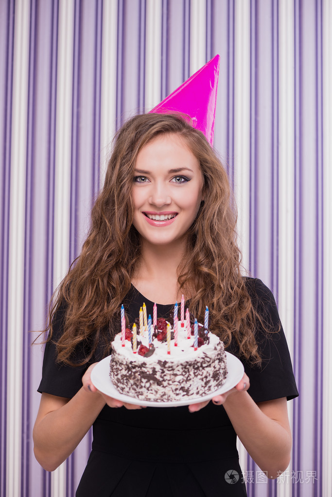 幸福的女人头戴生日帽蛋糕