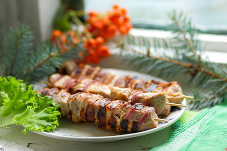 冷杉的枝条 罗文与绿叶生菜猪肉肉串烤熟在烤架上吃圣诞大餐设计器