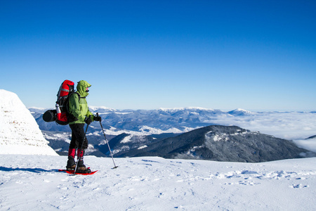 在山里徒步旅行带着背包和帐篷雪的冬天