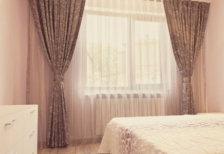 长长的黑豪华窗帘和薄纱窗帘，在卧室的窗户上的纱帘。室内设计理念。老式的着色，照片滤镜