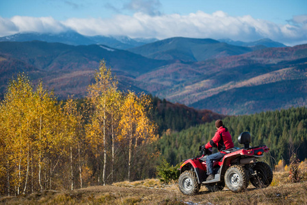 男性在 Atv 上驰在盘山公路上