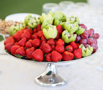 在板上的新鲜水果.草莓, 猕猴桃, 餐饮宴会桌上的葡萄.