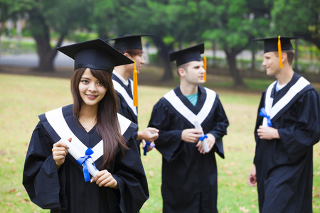 校园同学毕业快乐的学生,在大学校园毕业礼服照片