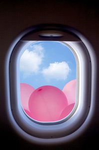 云彩和粉红色气球，飞机舷窗