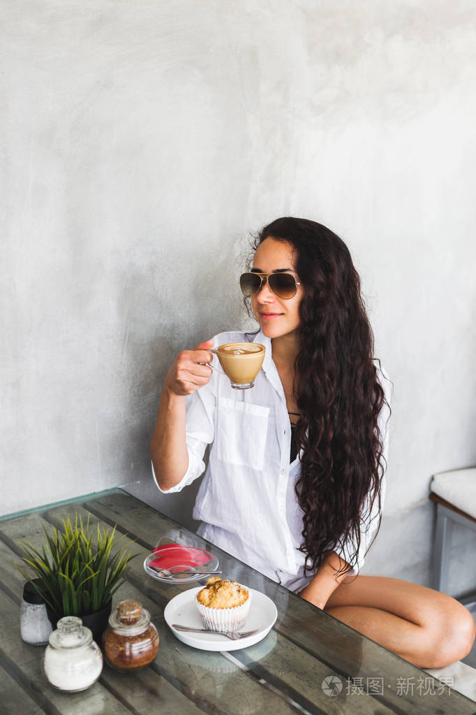 年轻的黑发女人喝咖啡