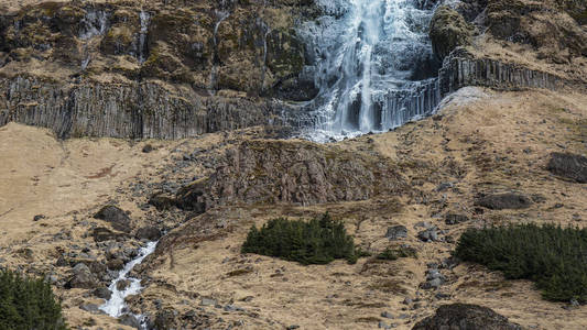 雄伟的景观，在冰岛的瀑布。一半冰冻融化后的冬天