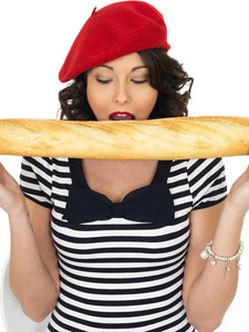 年轻漂亮的女人吃法国棍子面包