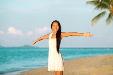 漂亮的女孩走在沙滩上日落，自由概念