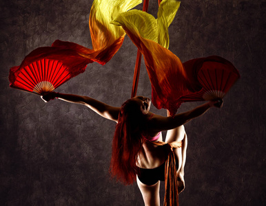 美丽的舞者在空中丝绸, 优雅的扭曲, 杂技演员表演一个丝带的把戏