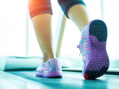 女人一步和在跑步机上运行在健身房健身