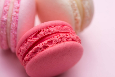 粉红色的美味蛋糕 macaron 或蛋白杏仁饼干在粉红色的背景上。特写