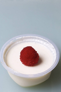 果冻酸奶罐子里装饰着覆盆子。在白色背景上
