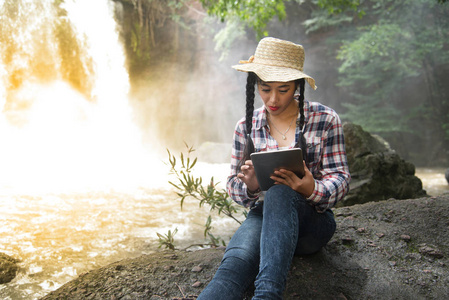 年轻的亚洲旅行者女人一款平板电脑在仰望幸福