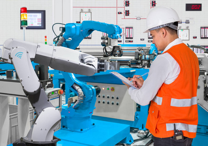 工程师检查维护每日的自动化机器人生产线，行业 4.0 概念
