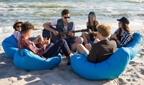 群好友一起在海滩聚会上吉他