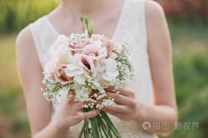 女人抱着她的多彩花束手在婚礼那天