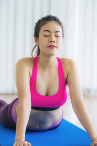在瑜伽垫上的室内健身房锻炼的年轻女人
