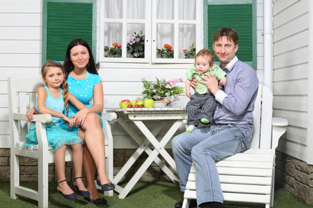 幸福的一家人坐在白色的木桌旁图片