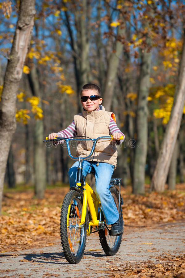 这个男孩在公园里骑自行车