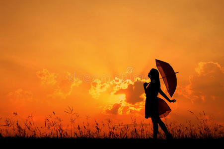 雨伞女子跳跃日落剪影