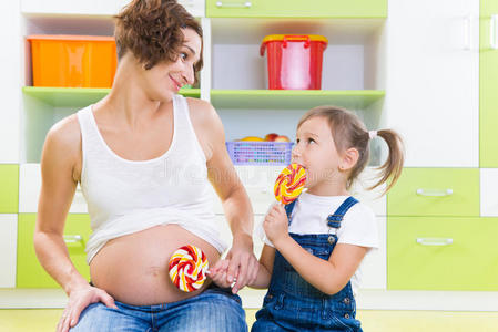 怀孕的母亲和女儿用棒棒糖