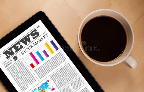 平板电脑在屏幕上显示新闻，桌上放一杯咖啡