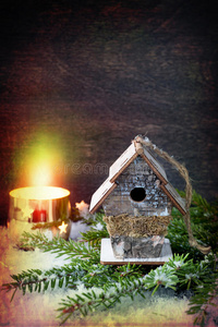 圣诞装饰品鸟舍和燃烧的蜡烛。 复古风格。