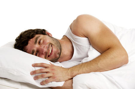 躺在白床上微笑的男人图片