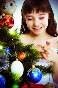在一棵圣诞树下的小微笑女孩