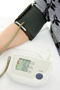手用血压计在白色背景上的一名老妇