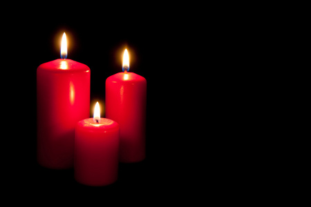 在黑暗中的三个红色蜡烛一套