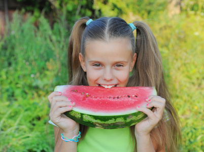 年轻的女孩吃西瓜