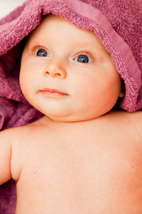 婴儿宝宝女孩微笑躺在紫毛巾