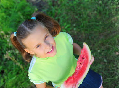 年轻的女孩吃西瓜