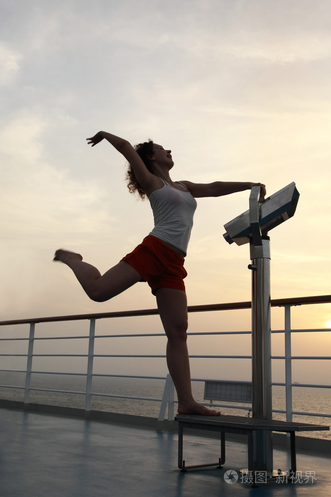 女孩练习体操练习在船甲板上充分的身体
