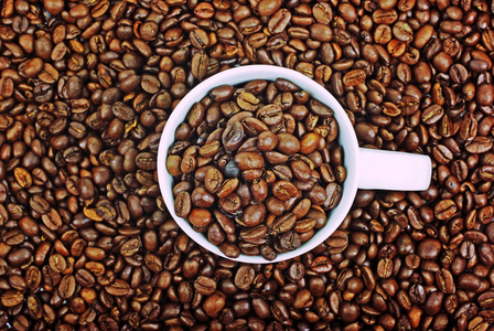 白杯咖啡褐色咖啡豆背景上的完整