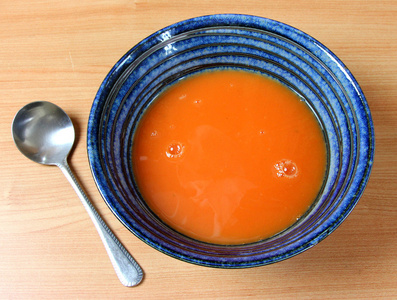 红番茄汤和勺子蓝陶瓷碗