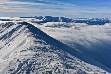 在冬天的山顶上的两名登山者