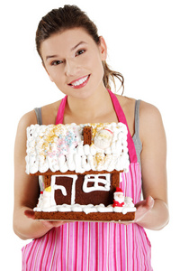 年轻女子持有姜饼房子模型图片