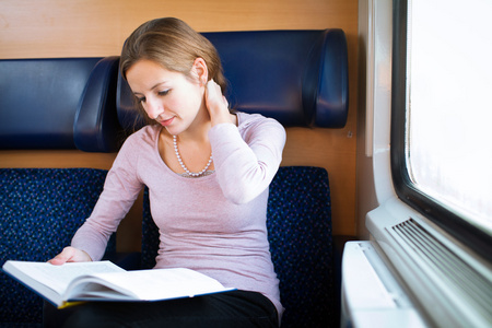 年轻女子读一本书上火车