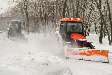 在公园里两个牵引车除雪