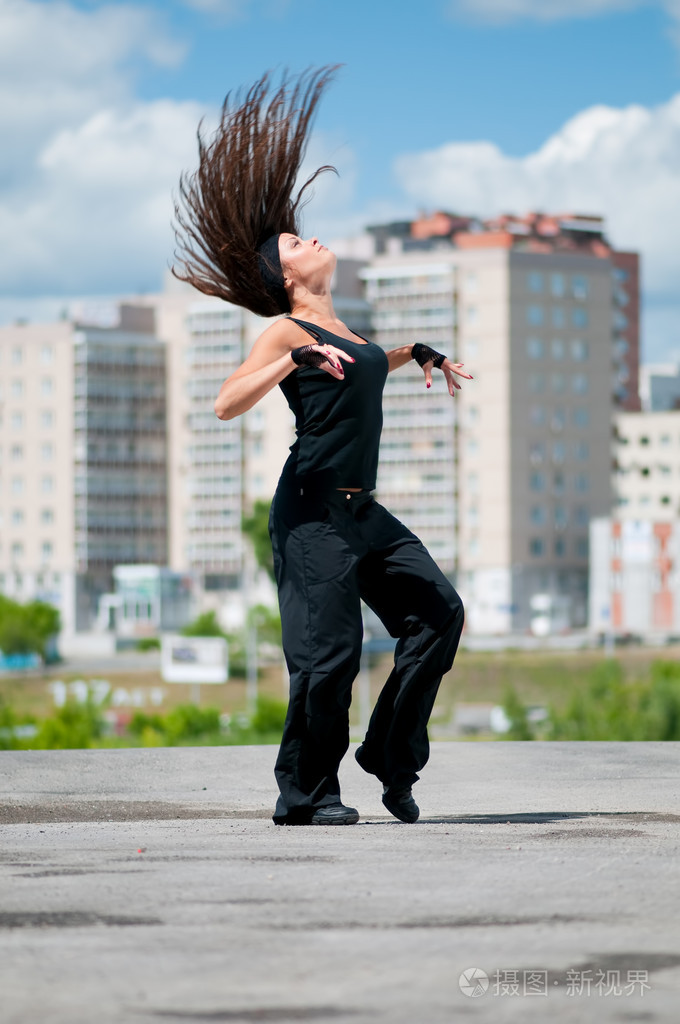 在城市景观跳街舞的漂亮女孩