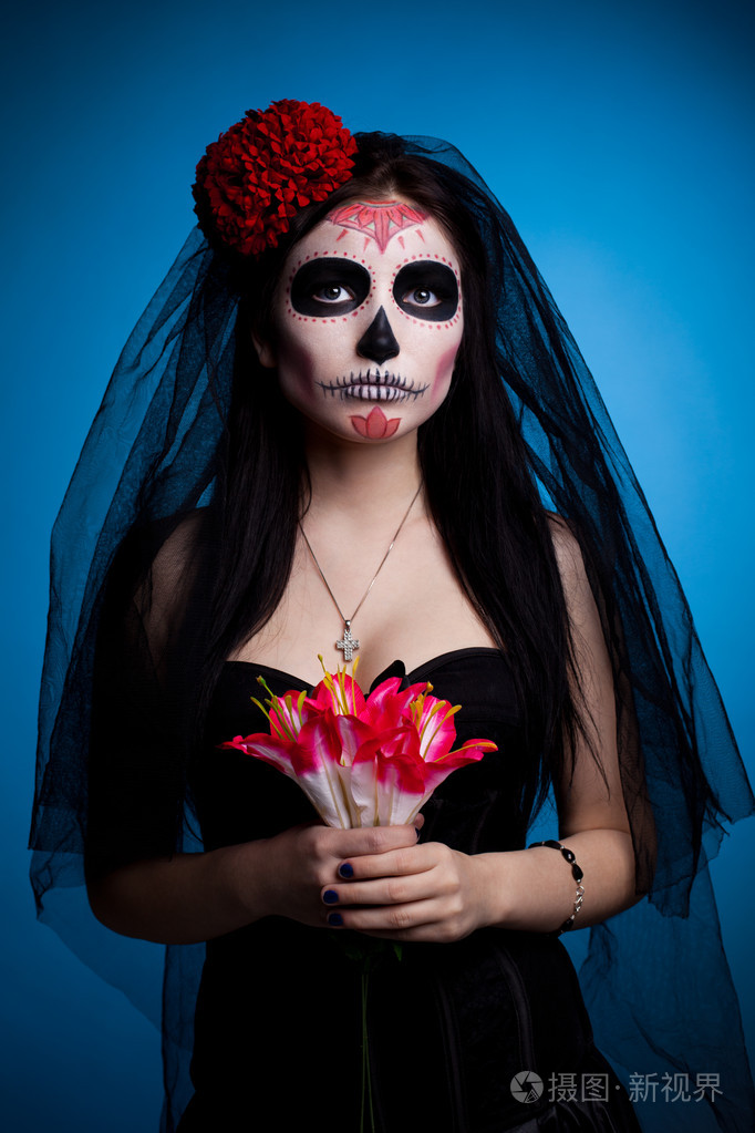 骷髅面罩艺术和鲜花的严重女人