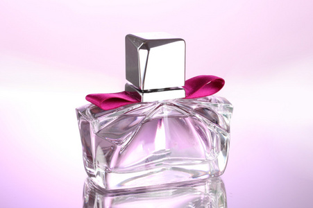 在美丽的瓶子粉红色背景上女式香水
