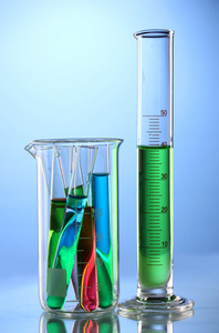 实验室玻璃器皿与颜色液体和思考蓝色 backgrou