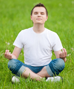 一个年轻人在做瑜伽在公园