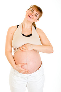 快乐美丽的孕妇摸她的肚子上白色隔离